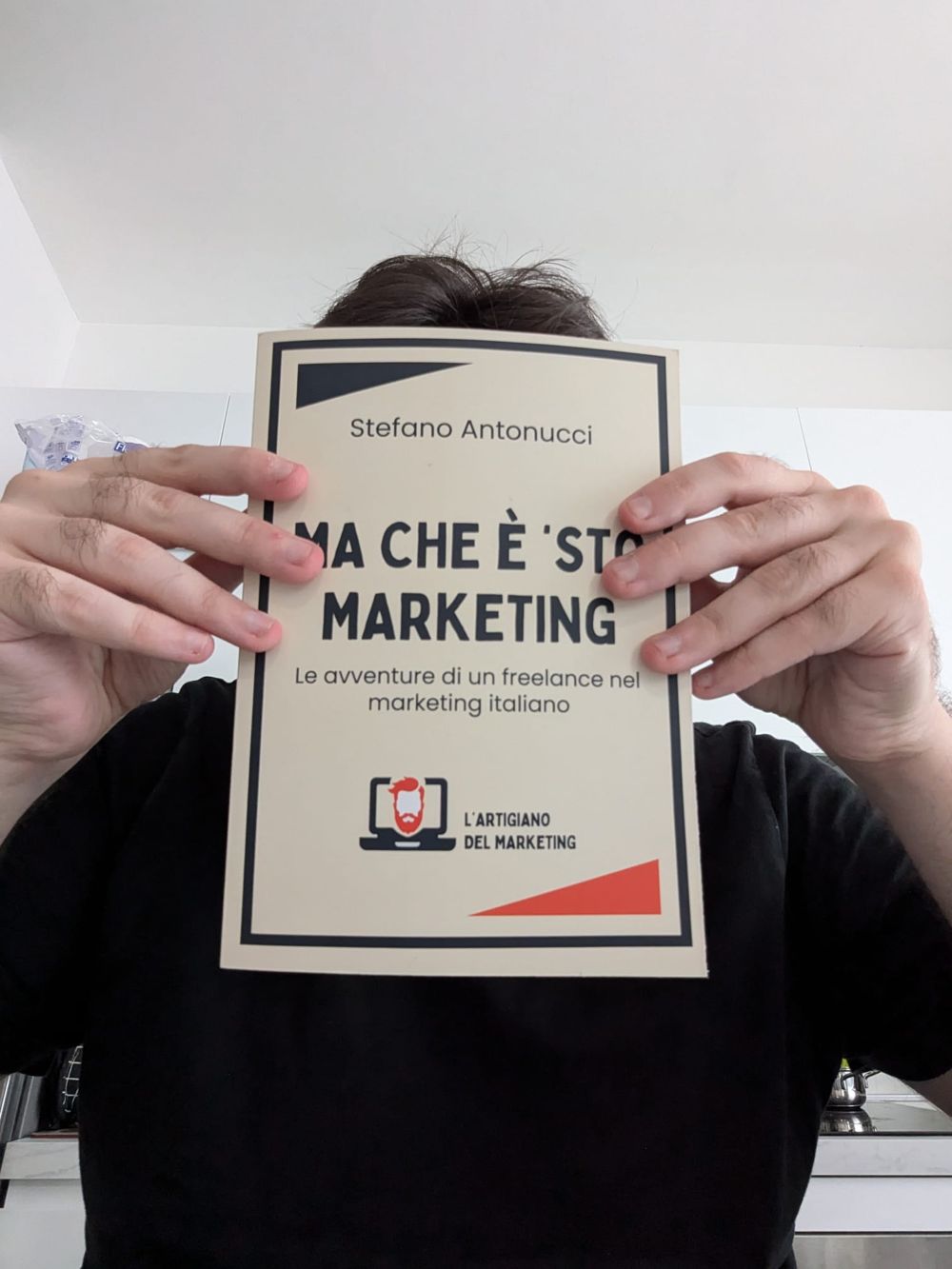 Il libro Ma che è ’sto marketing? tenuto davanti al viso